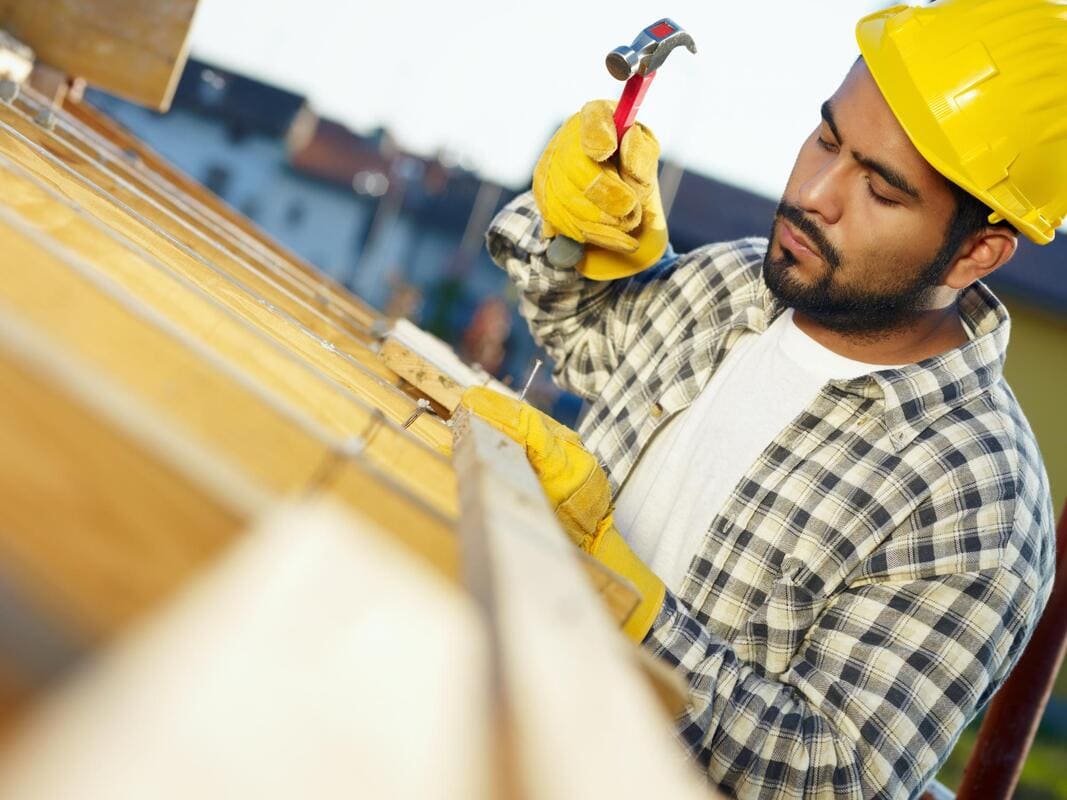 Roofer working near fascia at a roof edge